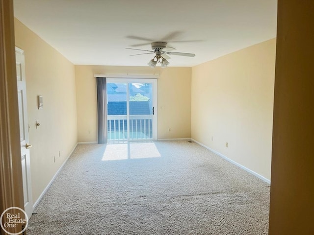 carpeted empty room featuring ceiling fan and baseboards