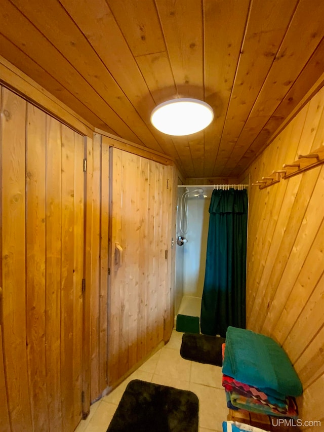 bathroom with curtained shower, wooden ceiling, tile patterned floors, and wooden walls