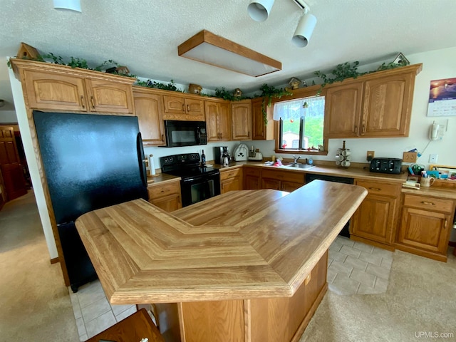 kitchen with light colored carpet, black appliances, sink, and a textured ceiling