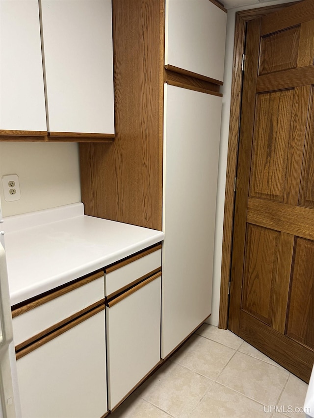clothes washing area with light tile patterned floors