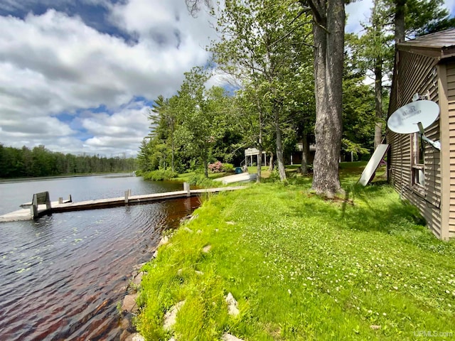 view of dock with a water view and a lawn