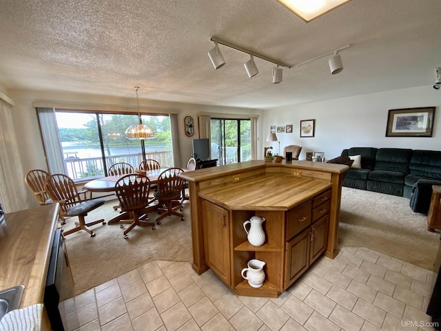 kitchen with open shelves, light tile patterned floors, light carpet, and open floor plan