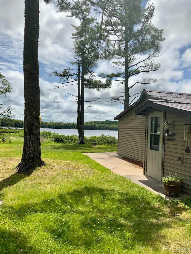 view of yard with a water view and a patio