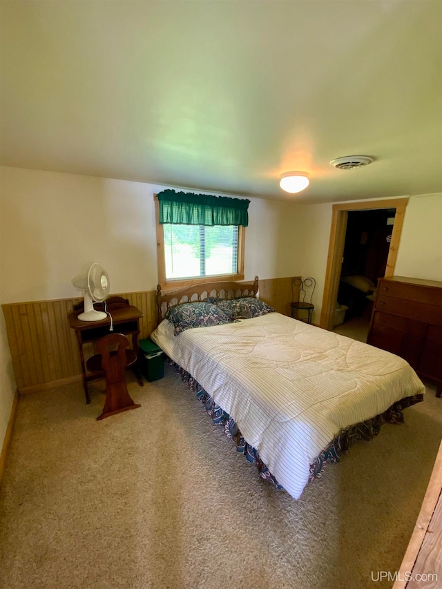 bedroom featuring wood walls and carpet flooring