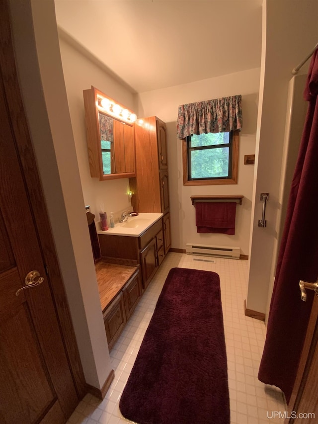 full bathroom with vanity, a baseboard radiator, baseboards, and tile patterned floors