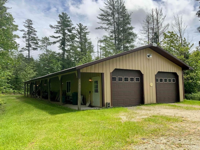 garage featuring wood walls and a yard