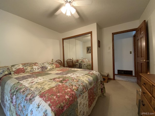 bedroom featuring light colored carpet, a ceiling fan, baseboards, and a closet