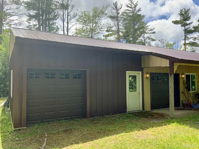 garage with wood walls and a lawn