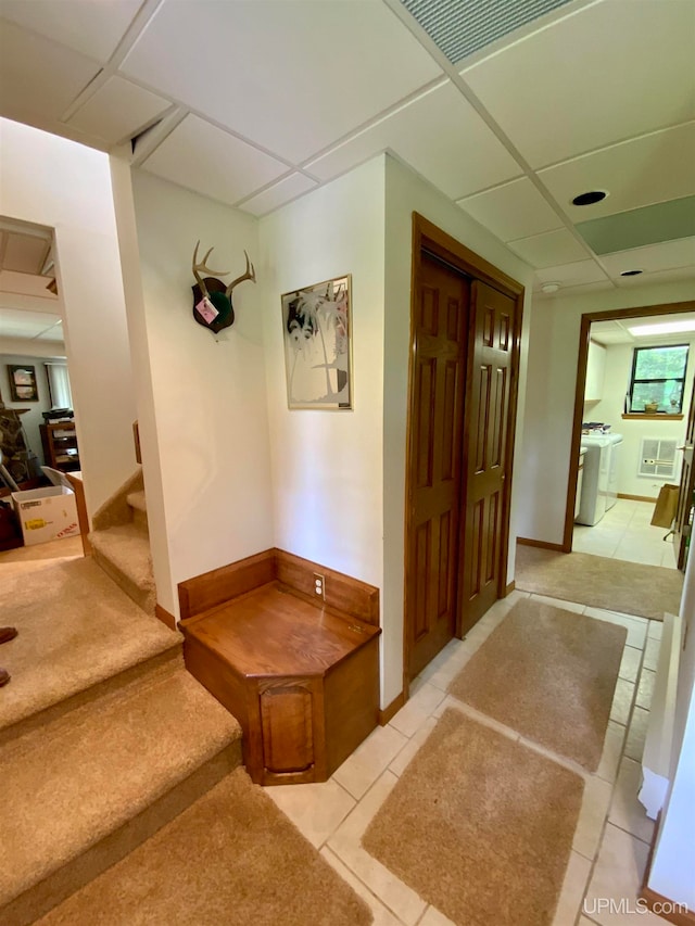 corridor featuring a drop ceiling and light tile patterned floors