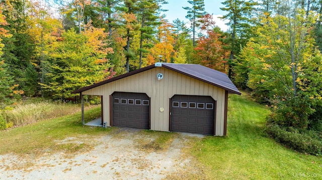 detached garage featuring a view of trees