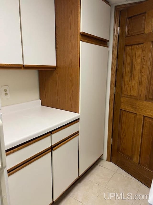 kitchen featuring light tile patterned floors and white cabinetry