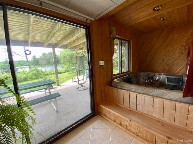 doorway to outside with light tile patterned flooring and wood walls