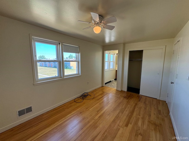 unfurnished bedroom with ceiling fan, light hardwood / wood-style floors, and a closet