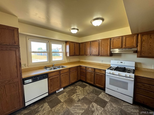 kitchen featuring sink, dark tile patterned floors, and white appliances