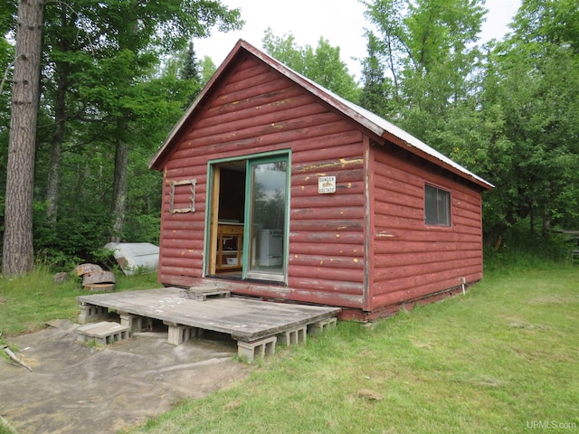 exterior space with a yard, an outbuilding, and a deck