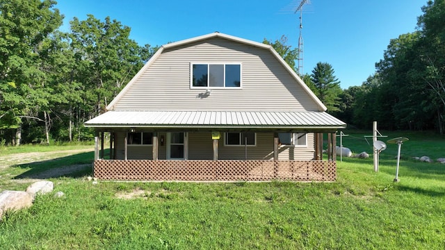 back of house featuring a lawn and a porch