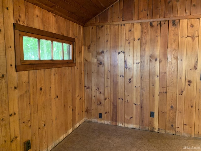 spare room with vaulted ceiling, wooden ceiling, and wood walls