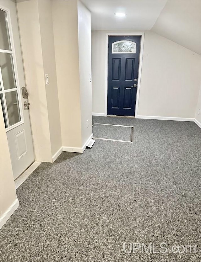 carpeted entrance foyer with lofted ceiling