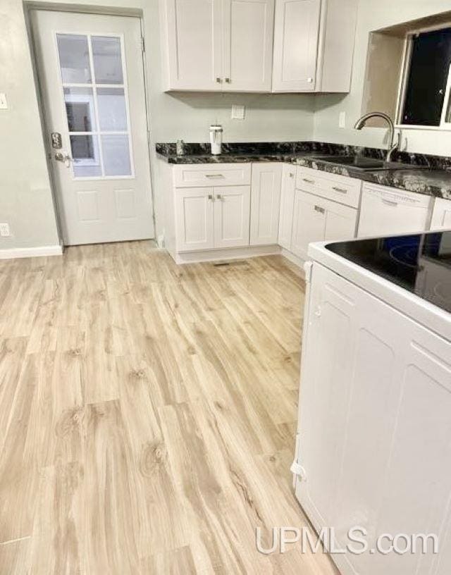 kitchen featuring sink, light hardwood / wood-style flooring, white appliances, and white cabinetry