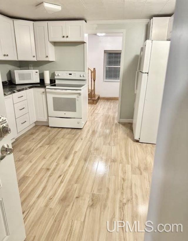 kitchen featuring white cabinets, light hardwood / wood-style floors, crown molding, and white appliances