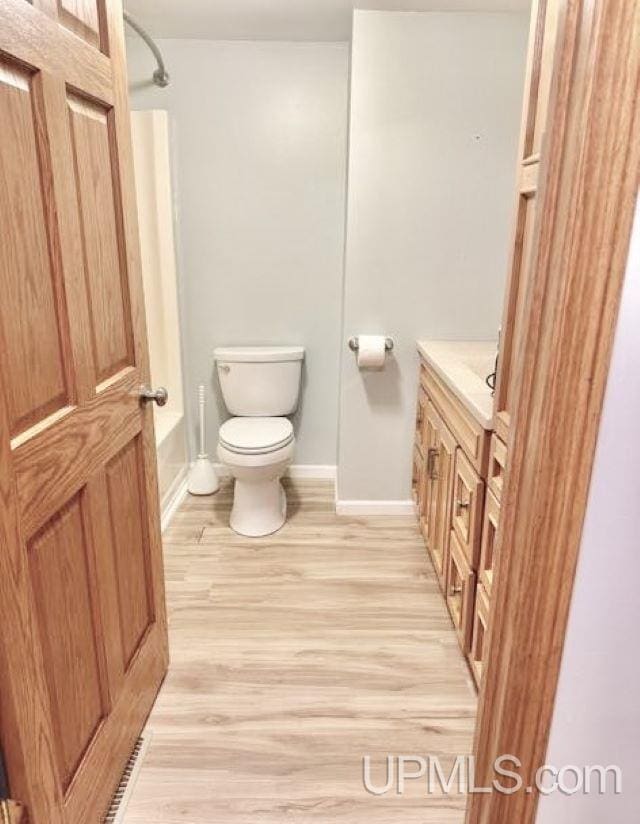 bathroom with vanity, wood-type flooring, and toilet