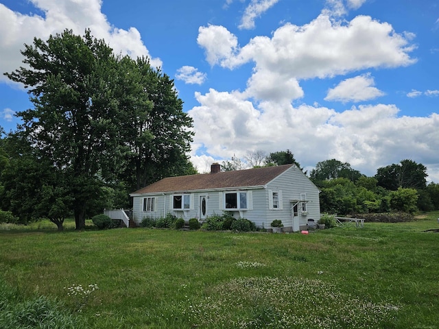 ranch-style house with a front lawn and a chimney