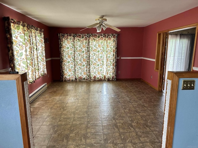 empty room featuring baseboard heating and a ceiling fan