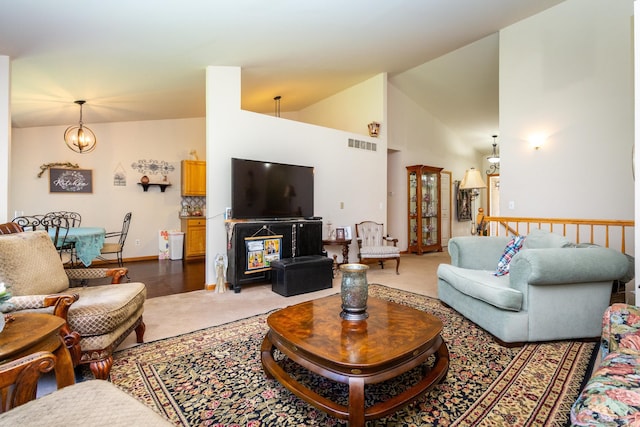 living room featuring an inviting chandelier, wood-type flooring, and high vaulted ceiling