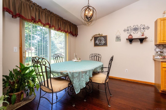 dining area with wood-type flooring and an inviting chandelier