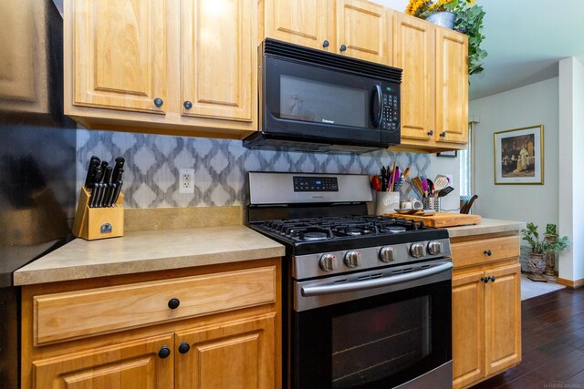 kitchen featuring decorative backsplash, dark hardwood / wood-style flooring, and gas stove