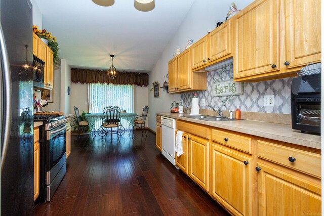 kitchen featuring tasteful backsplash, stainless steel appliances, sink, decorative light fixtures, and dark hardwood / wood-style flooring