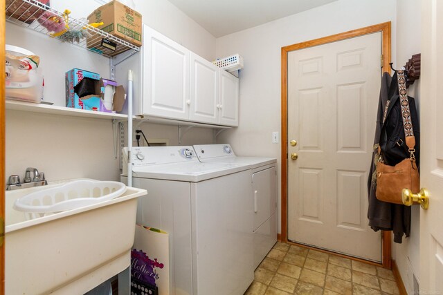 washroom featuring sink, cabinets, washer and dryer, and light tile patterned floors