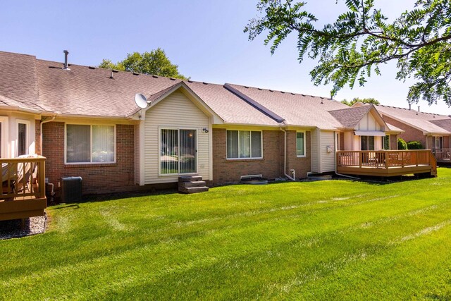 rear view of house featuring cooling unit, a wooden deck, and a yard