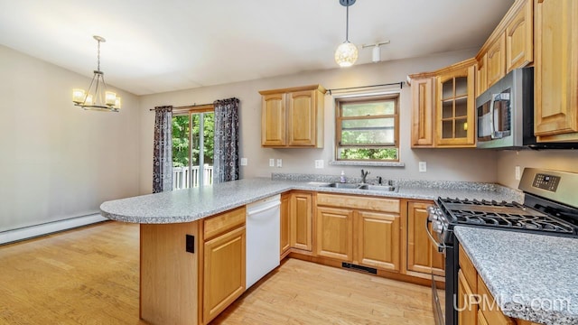 kitchen with a healthy amount of sunlight, kitchen peninsula, stainless steel appliances, and light hardwood / wood-style floors