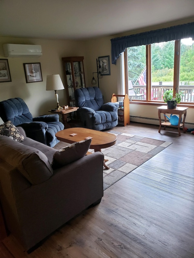 living room featuring a baseboard radiator, a wall mounted air conditioner, and light hardwood / wood-style floors