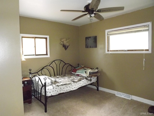 bedroom with light colored carpet, ceiling fan, and multiple windows