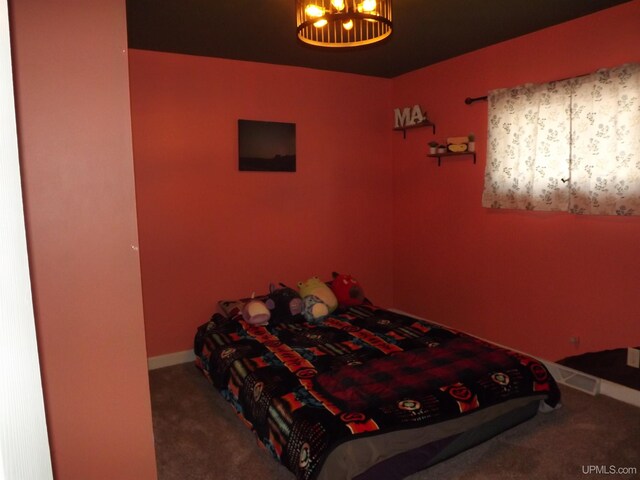 bedroom with a notable chandelier and carpet floors