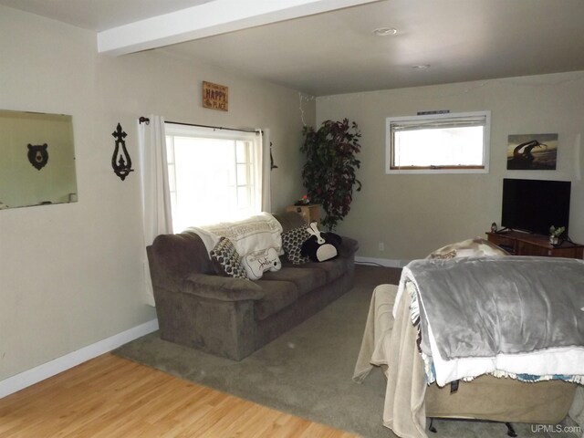 bedroom with beam ceiling and light hardwood / wood-style floors