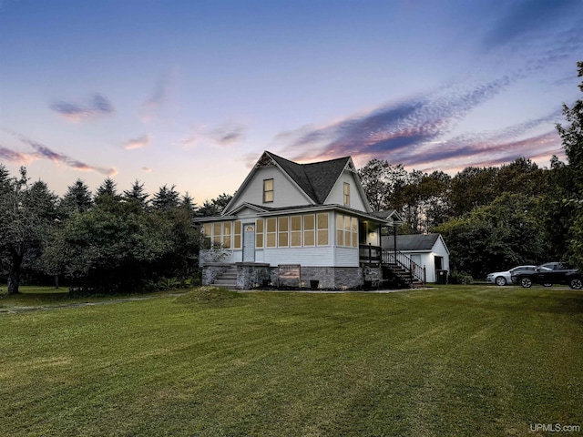 farmhouse-style home with a lawn and a sunroom