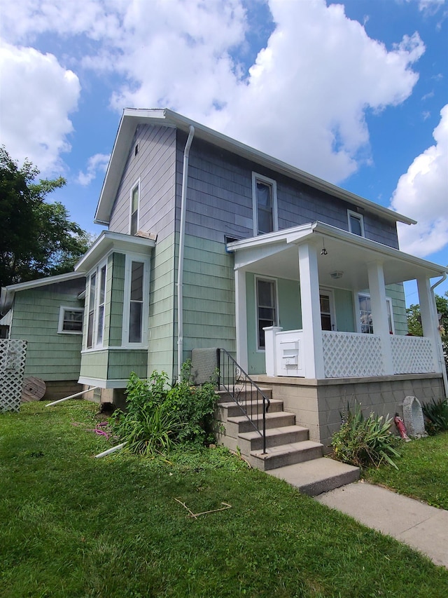 view of front of home with a front yard and covered porch