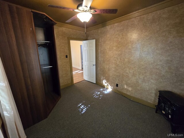 unfurnished bedroom featuring ceiling fan, ornamental molding, and carpet floors