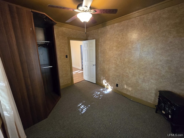 unfurnished bedroom with carpet, a ceiling fan, and crown molding