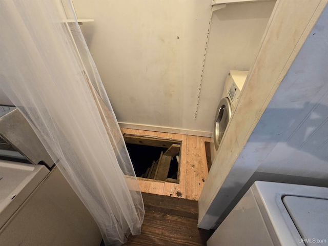 stairway featuring washer / clothes dryer and hardwood / wood-style flooring