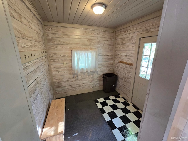 interior space with wooden ceiling, tile patterned floors, and wood walls