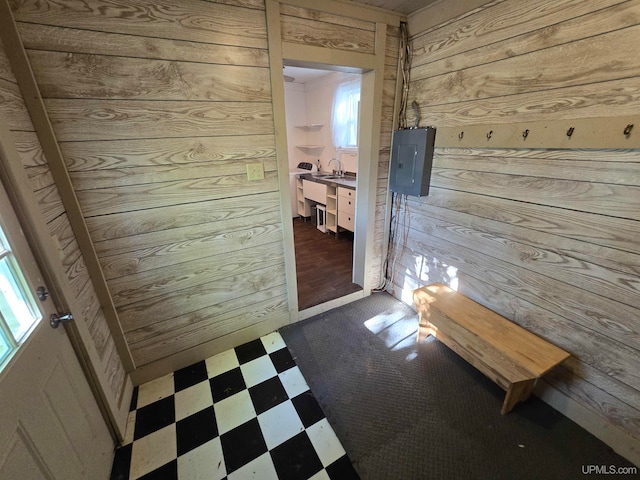 interior space featuring tile patterned floors, a wealth of natural light, wooden walls, and sink