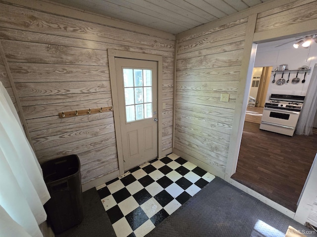 doorway featuring wooden ceiling, wood walls, and tile patterned floors