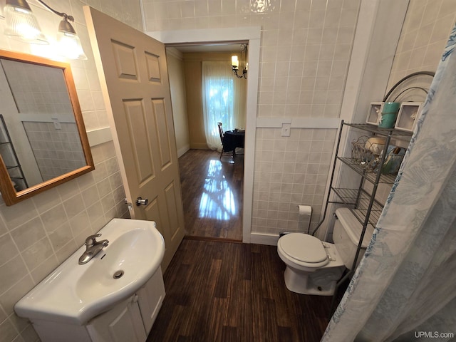 bathroom featuring tile walls, hardwood / wood-style flooring, and toilet