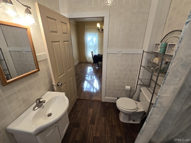 bathroom featuring toilet, vanity, tile walls, and wood finished floors