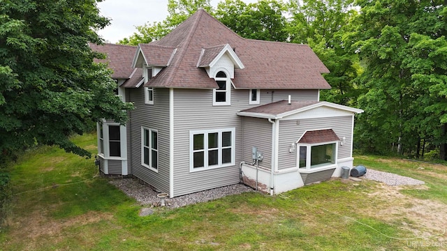 rear view of property featuring a lawn