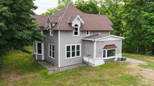 rear view of house featuring a lawn